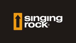 Logotyp czeskiego prducenta sprzętu firmy Singing Rock. Logo na czarnym tle przedstawia czarną strzałkę skierowaną ku górze wpisaną w żółty kwadrat znajdujący się po lewej stronie i napisu w dwóch wierszach Singing Rock w kolorze czarnym.