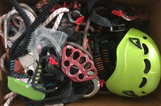 Karton pełen uszkodzonego sprzętu chroniącego przed upadkiem z wysokości, który służy do nauki i odnajdowania potencjalnych uszkodzeń.