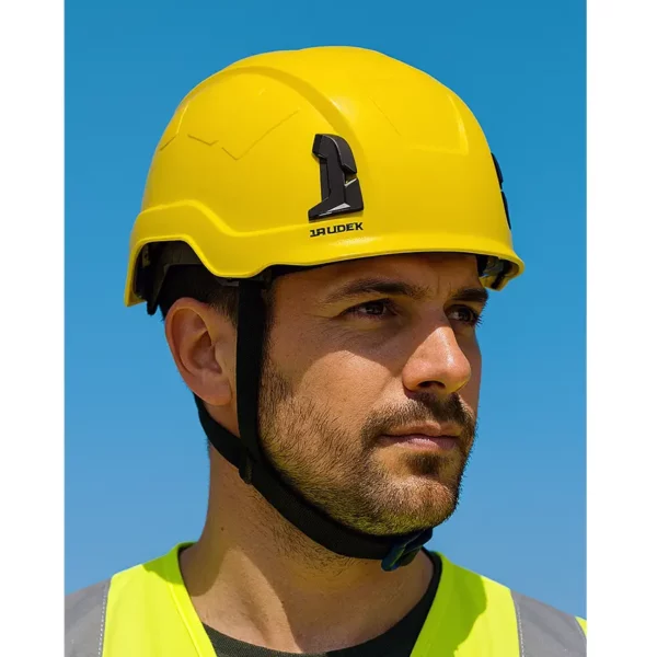 Zbliżenie na mężczyznę w żółtym kasku ochronnym Irudek Oreka II i kamizelce odblaskowej.