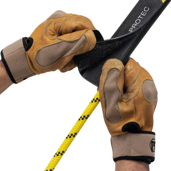 Ręce w skórzanych rękawicach zakładają ochronę Petzl PROTEC na żółtą linę roboczą.